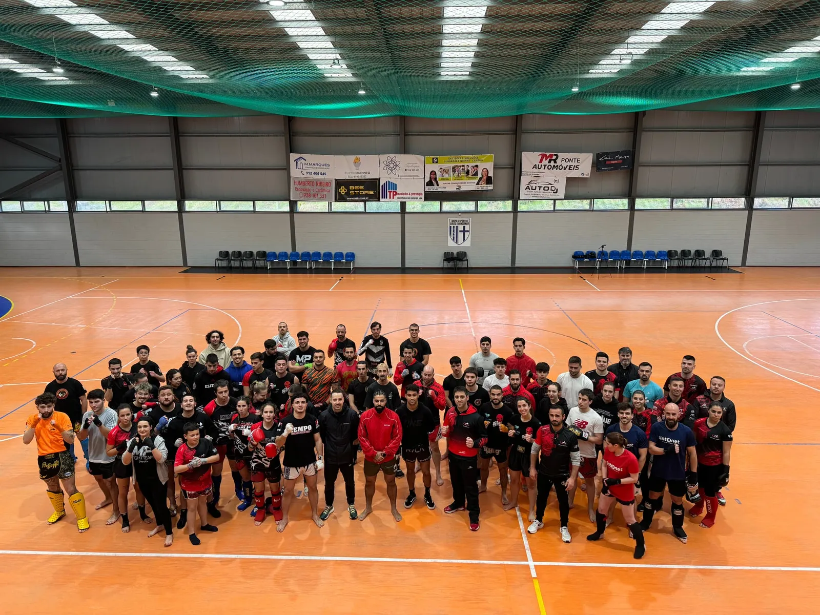 A seminar group photographed in a sports hall with Rui Botelho